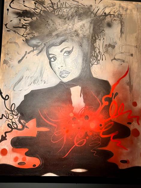 An abstract painting of a female figure with a dramatic hairstyle and bold eyeliner, surrounded by splashes of red and dark swirling patterns.